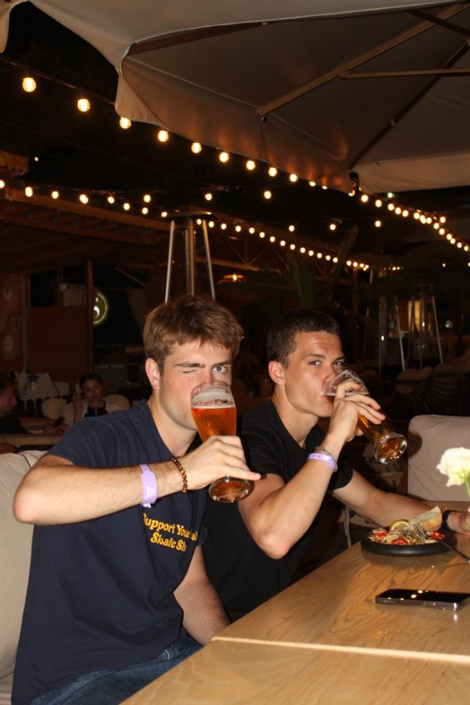 Two guys drinking beers at a bar